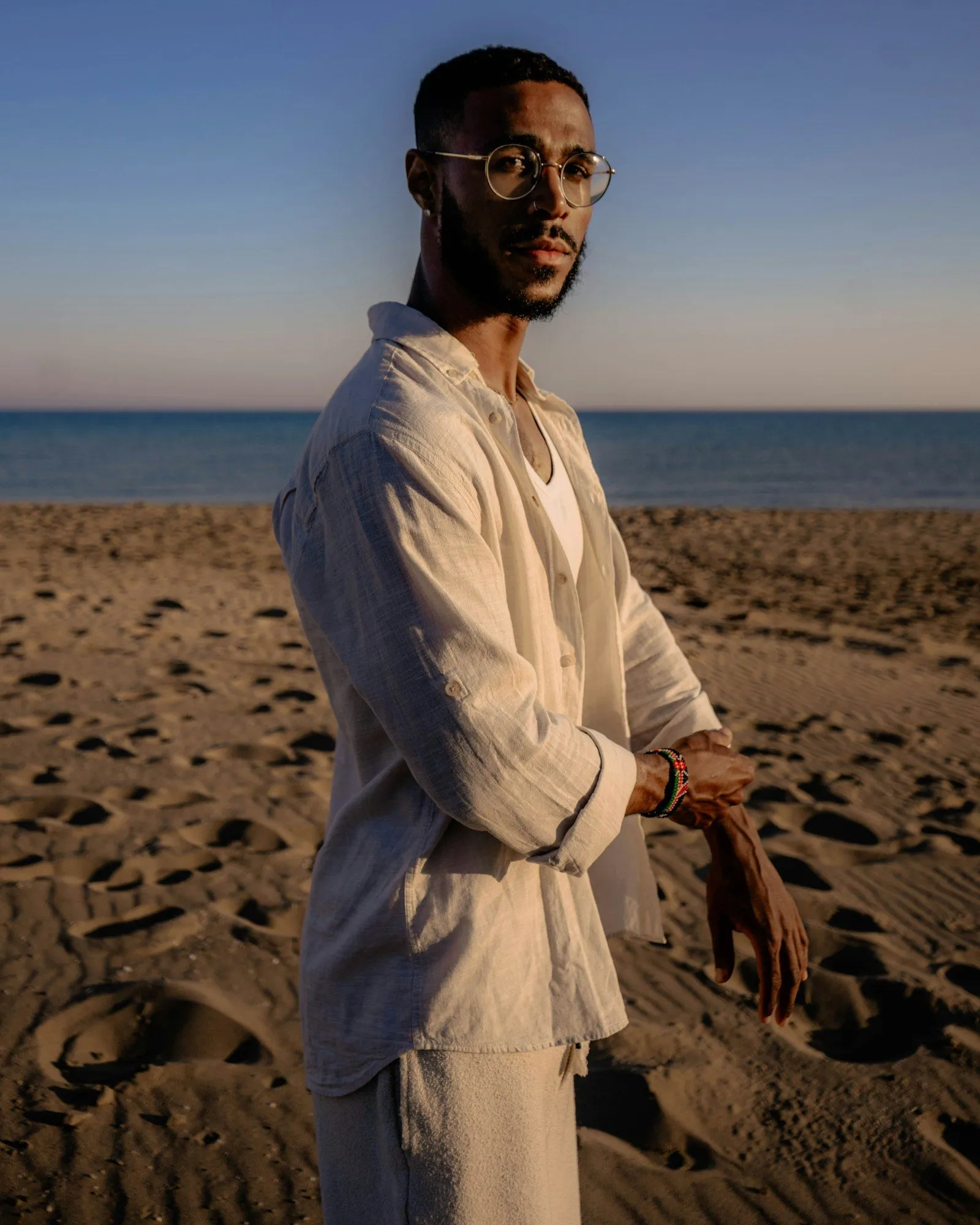 Man in light linen clothing on a sandy beach